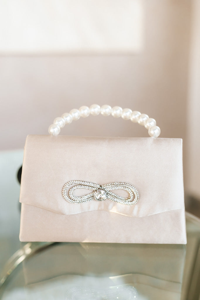 Satin Pearl Handle Center Stone Rhinestone Bow Clutch