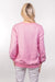 A close-up, back view of our model, Lexi, wearing a baby pink sweatshirt, tastefully embellished with white pearls on the front and sleeves. The back doesn't have any pearls.