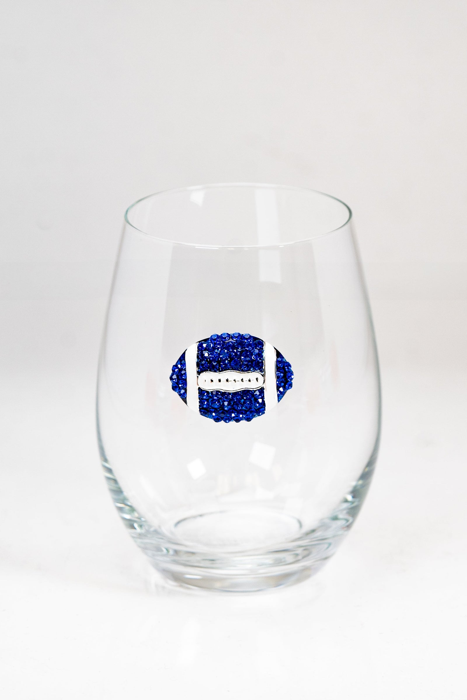 A stemless wine glass with a blue and white rhinestone football on the front.