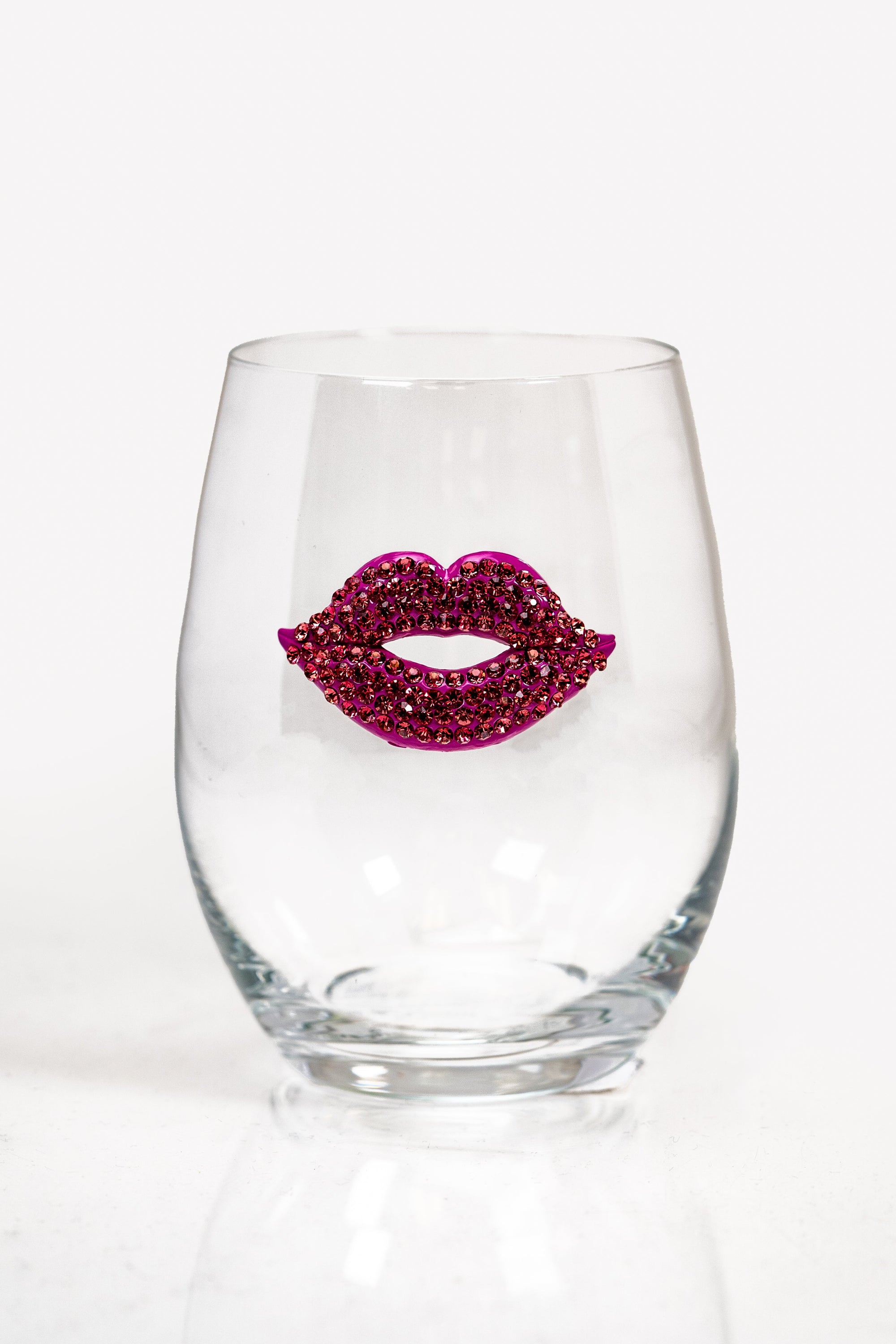 A stemless wine glass with magenta rhinestone lips on the front.