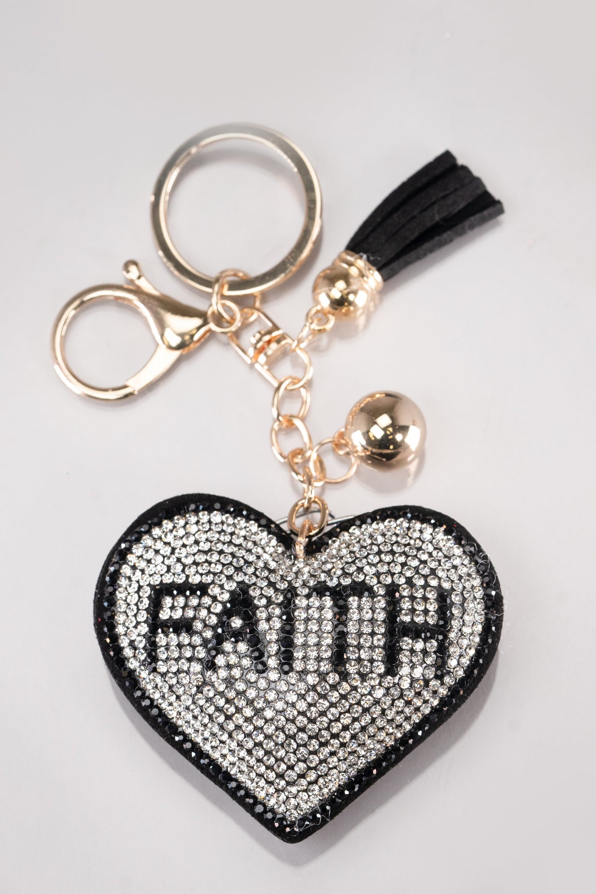 A front view of a black and silver puffy heart keychain with rhinestone embellishment and gold hardware.