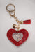 A front view of a red puffy heart keychain embellished with red and AB rhinestones, and has gold hardware.