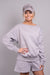 A close-up front-facing view of our model, Lexi, wearing a fleece sweatshirt and shorts set, in Light Gray