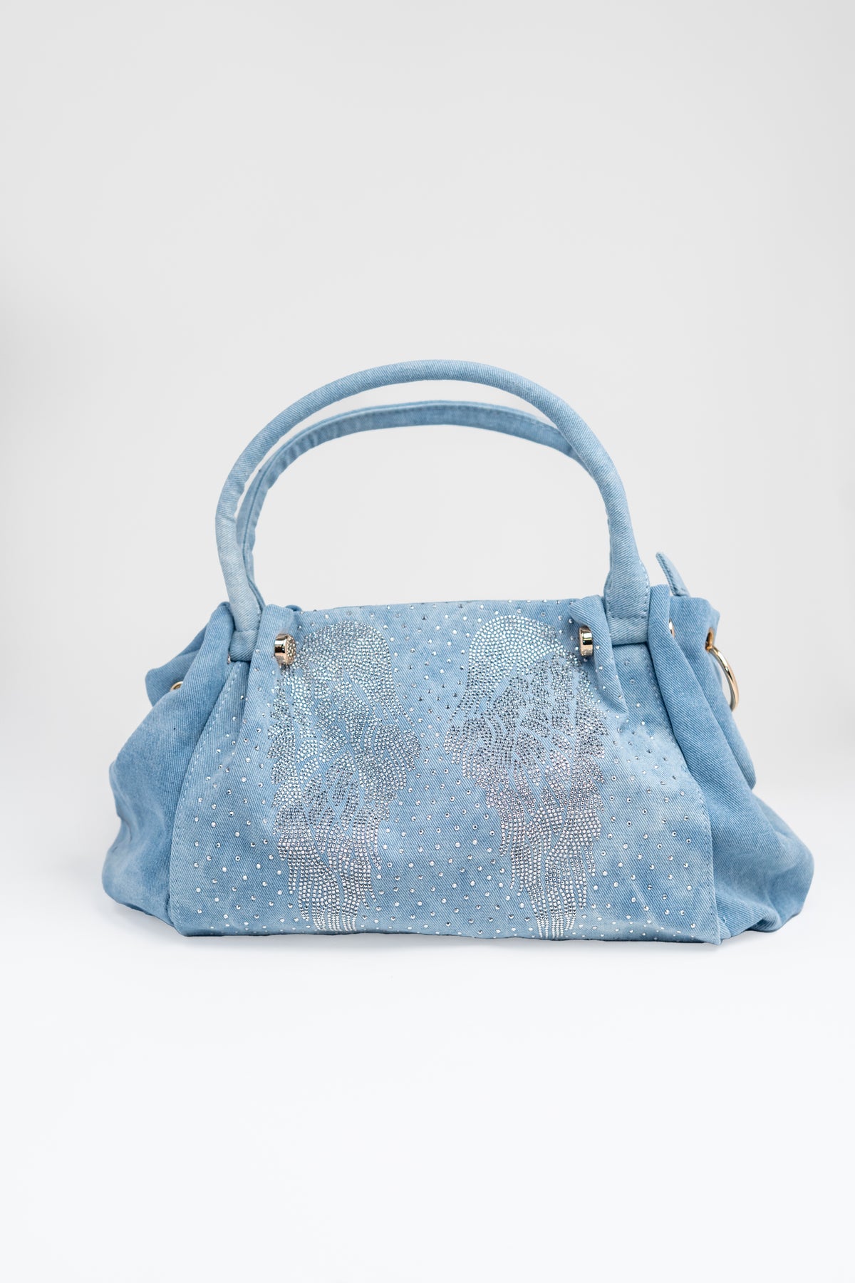 A front view of a light-wash denim handbag with rhinestone embellishment.