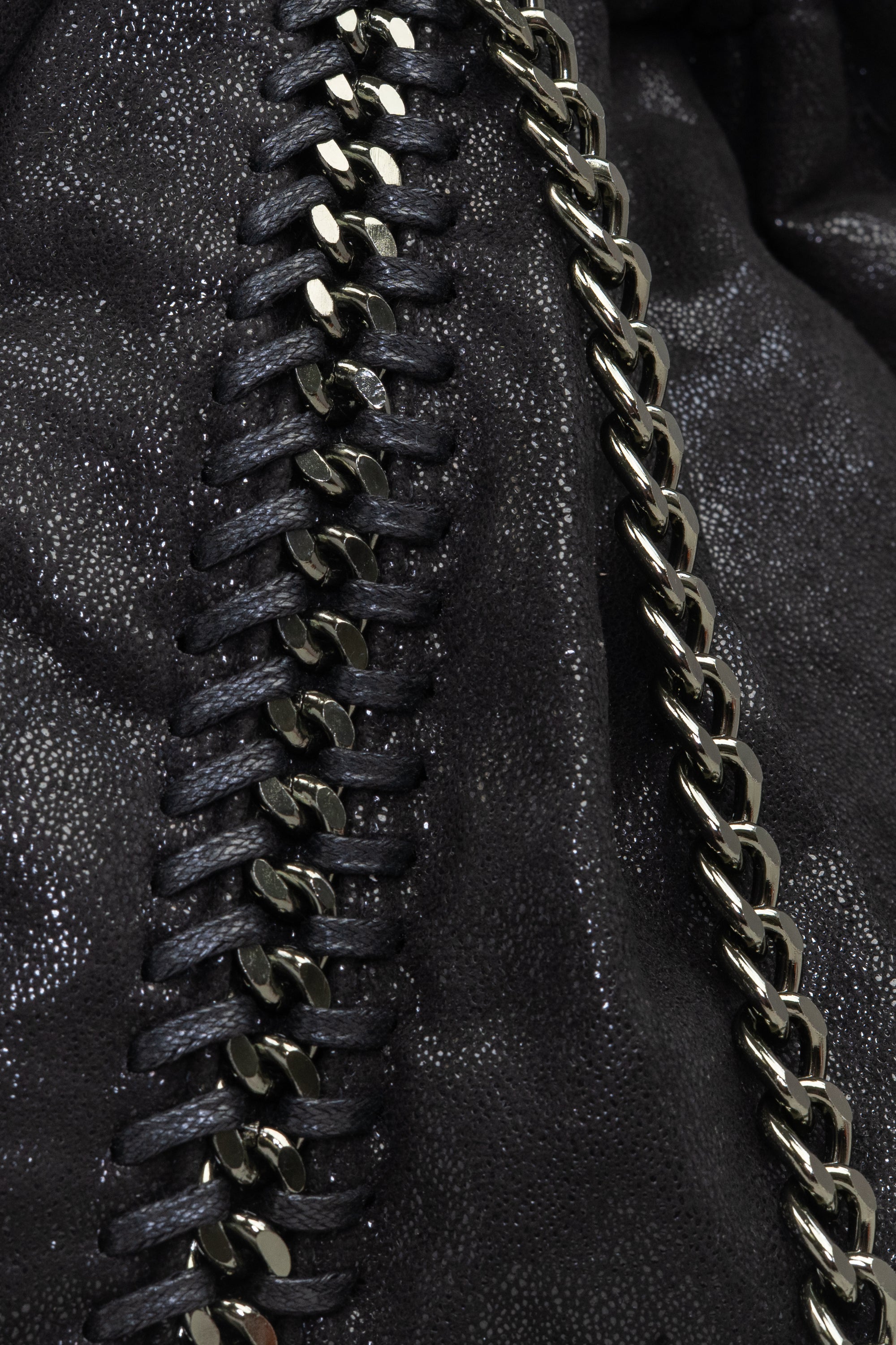 A close up of our black shimmery hobo bag with chain straps. This view is showing the incredible way the chain straps are intricately woven into the shimmery fabric.